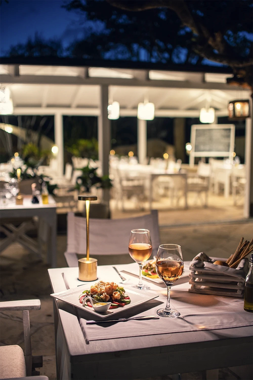 Elegant dinner setting with Mediterranean cuisine and wine at Kobe Suite Resort