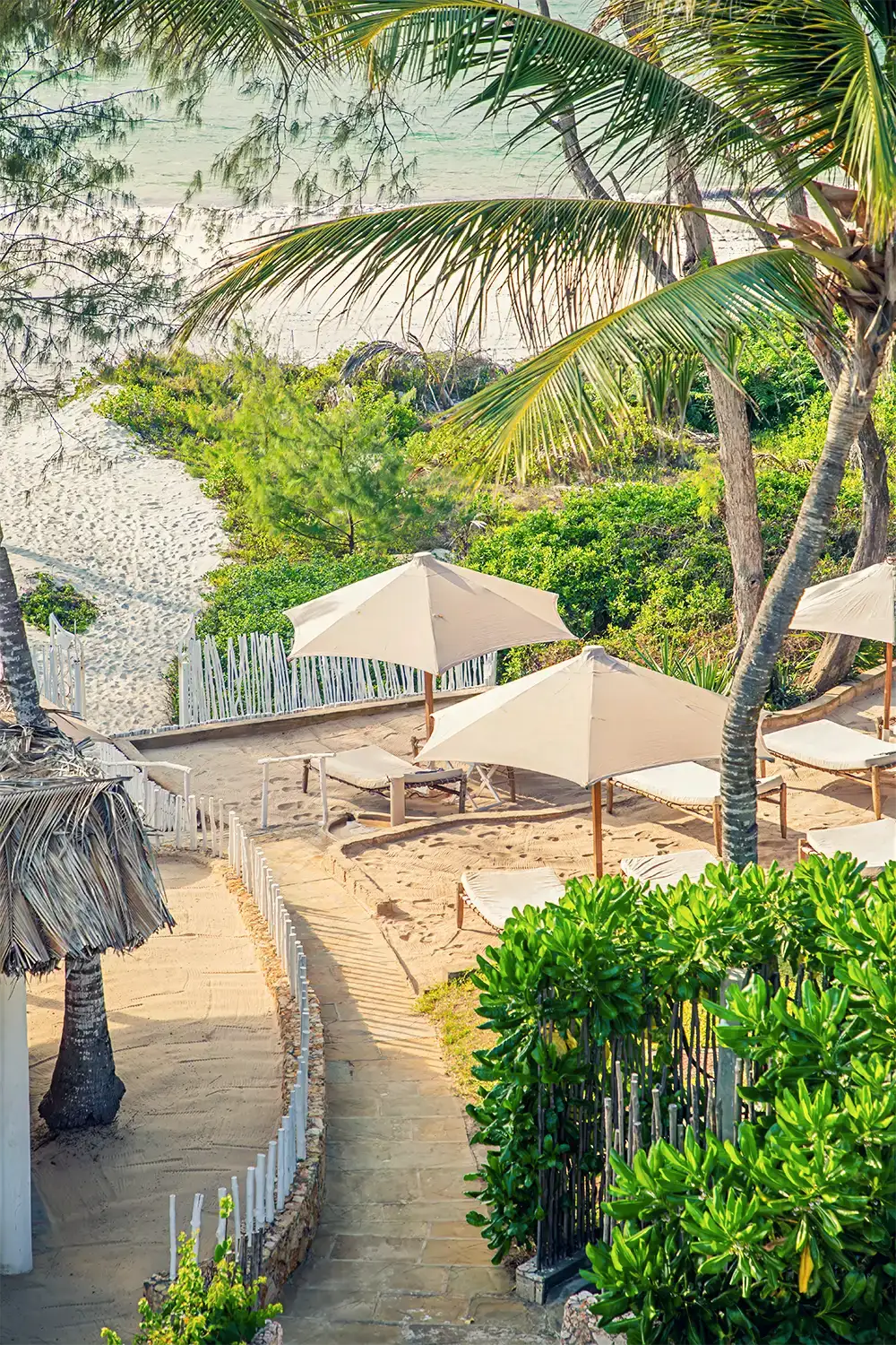 Private beach area with sun loungers and umbrellas beside the Indian Ocean