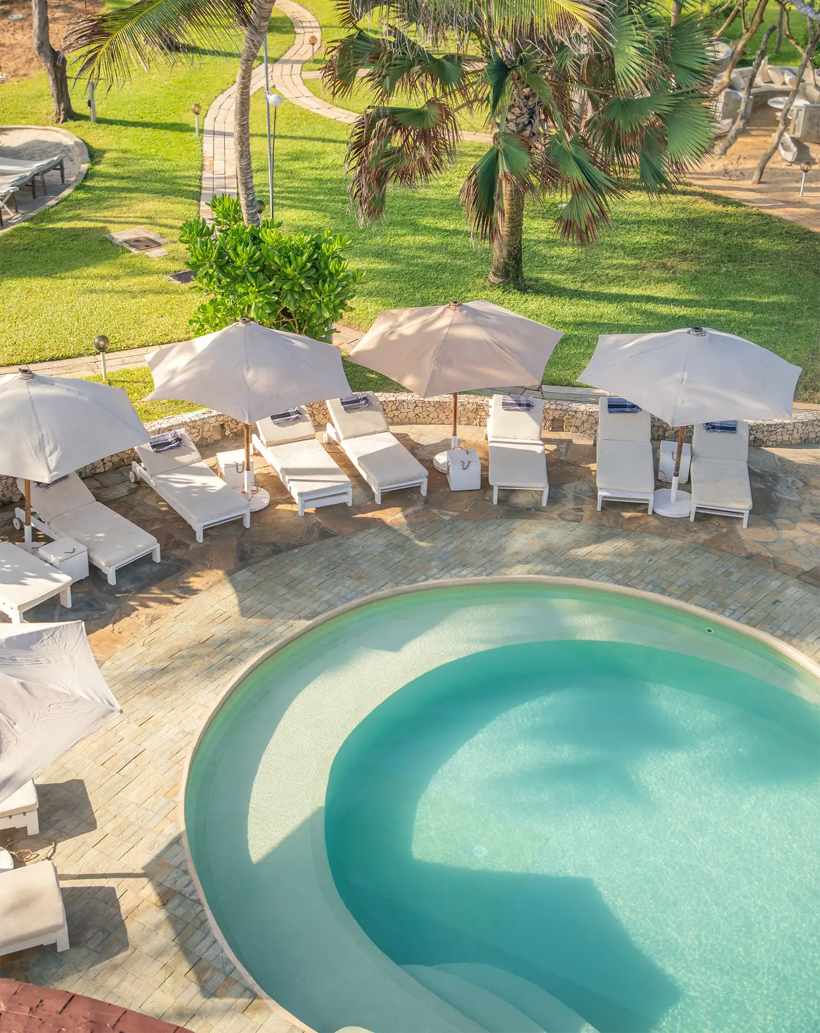 Poolside relaxation area surrounded by tropical gardens at Kobe Suite Resort
