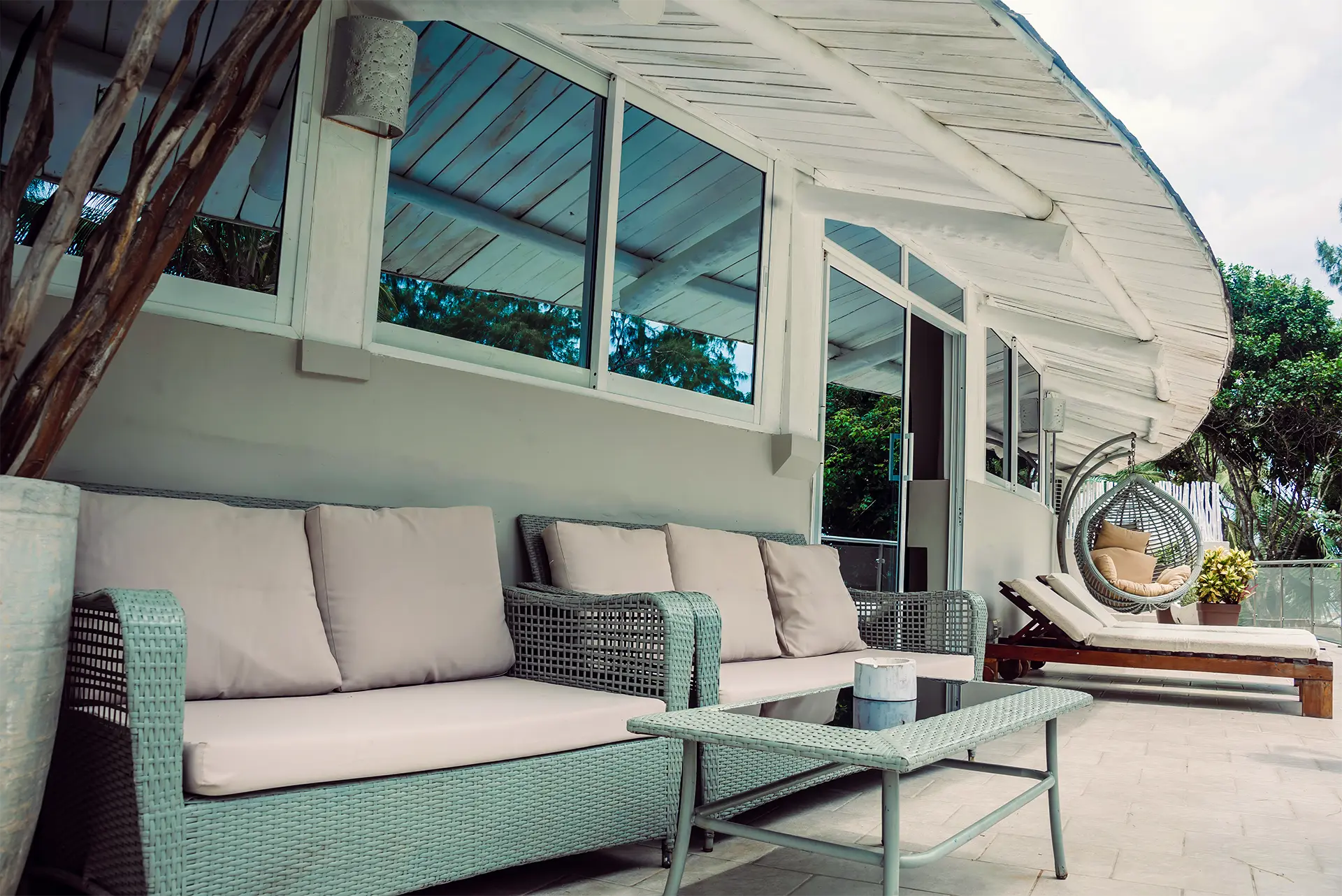 Private terrace with outdoor seating and hanging chair at the Deluxe Ocean View Suite