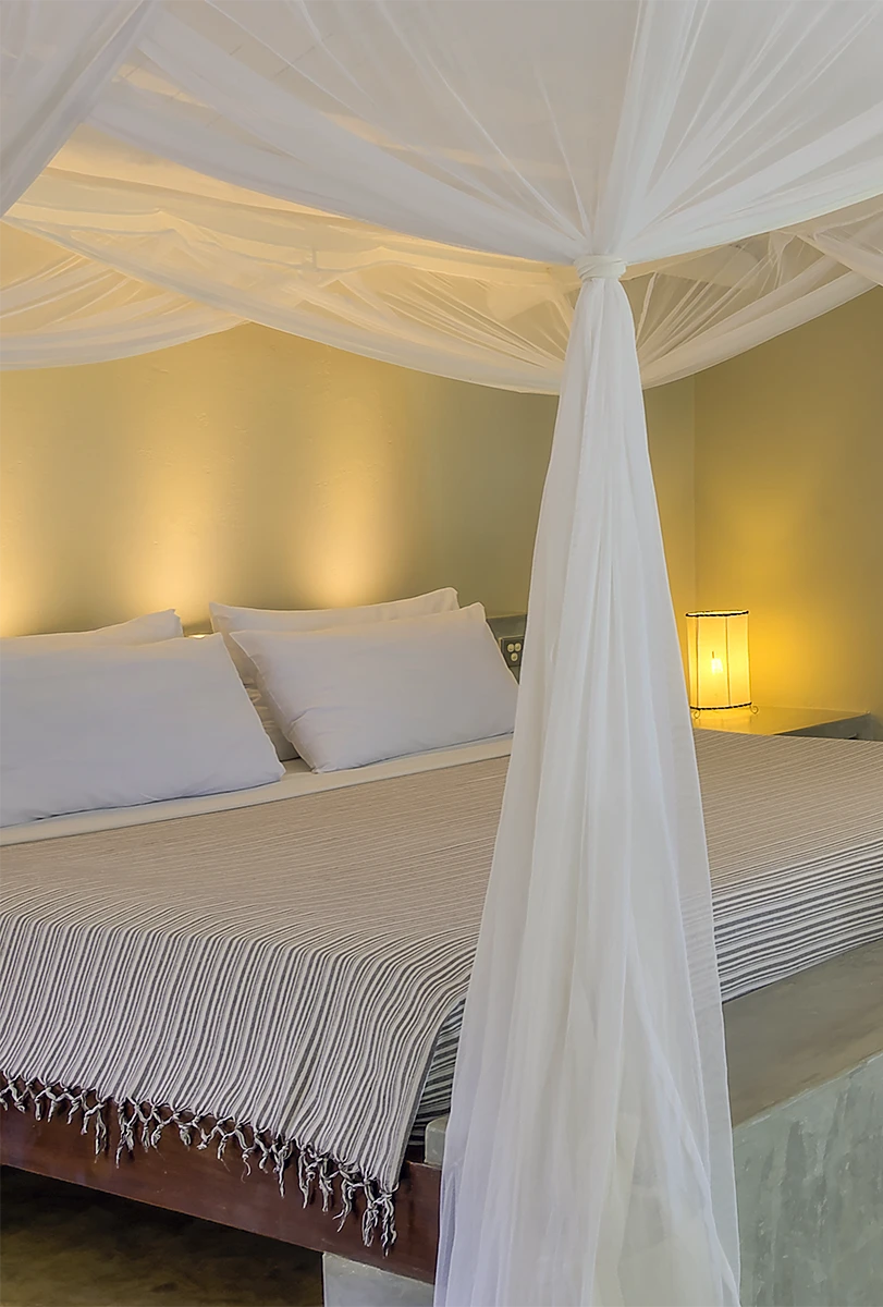 Deluxe Ocean View Suite bedroom with king-size bed and mosquito net