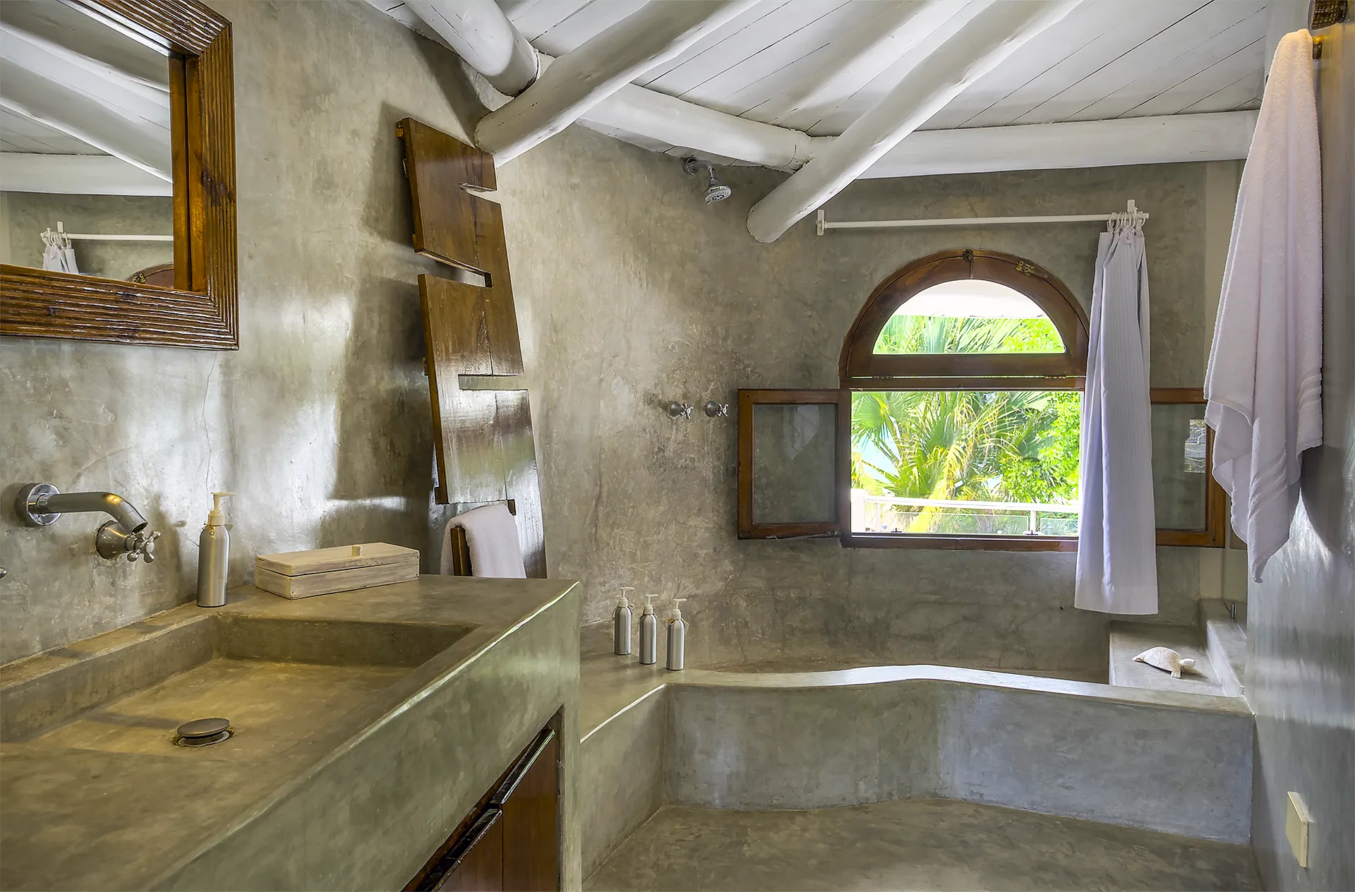 Bathroom with concrete vanity, bathtub and tropical garden view in the Deluxe Ocean View Suite