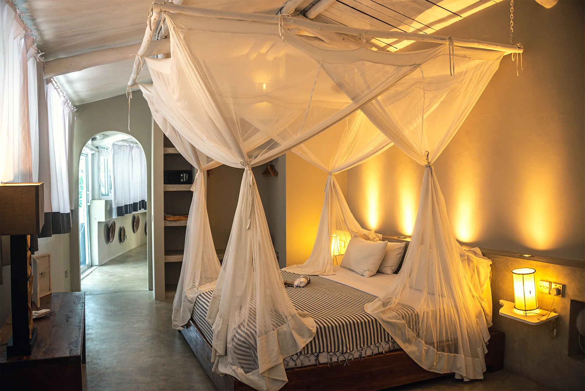 Deluxe Ocean View Suite bedroom with four-poster bed and mosquito net