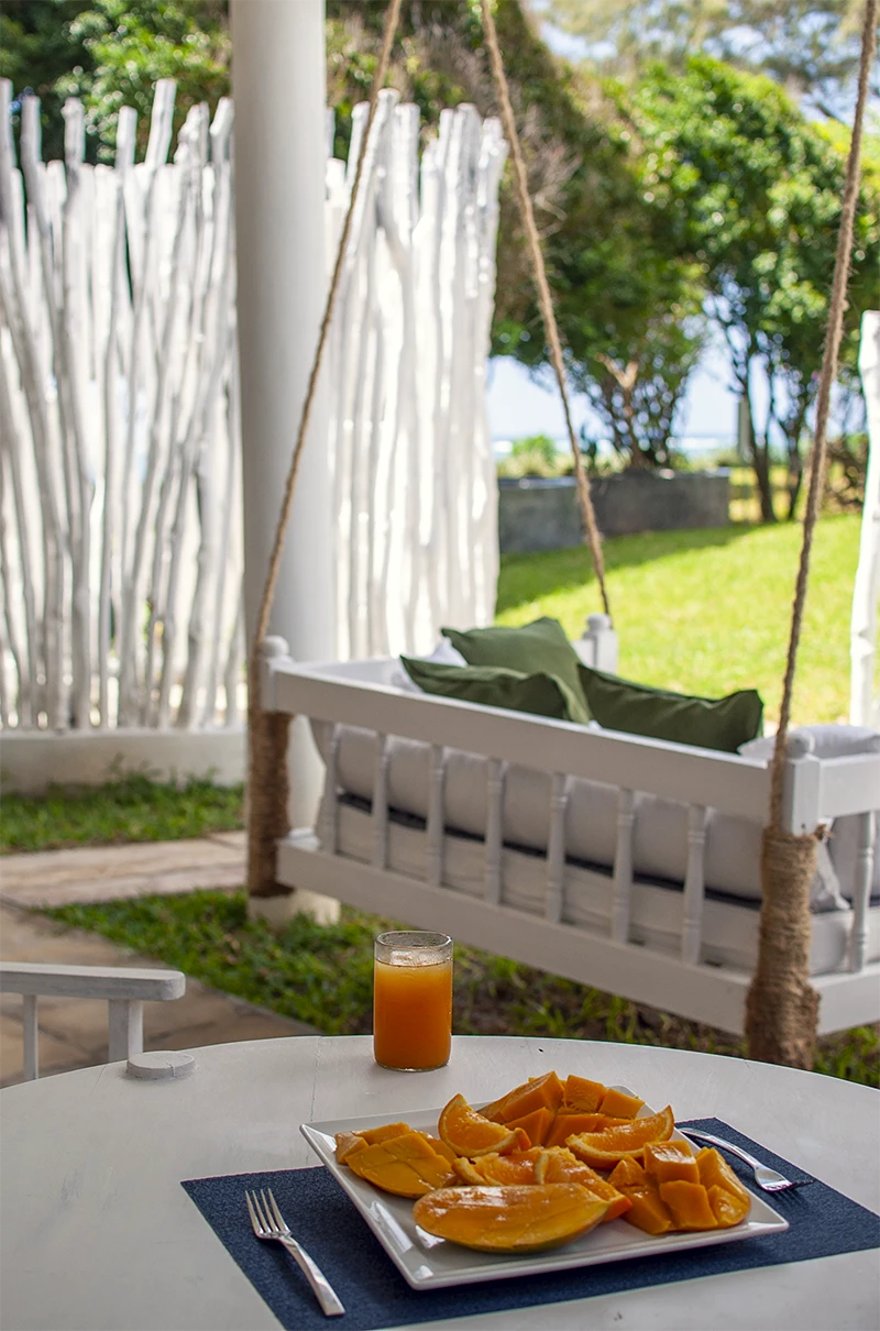 Private outdoor seating area with fresh fruit and tropical garden views at the Premium Garden View Suite