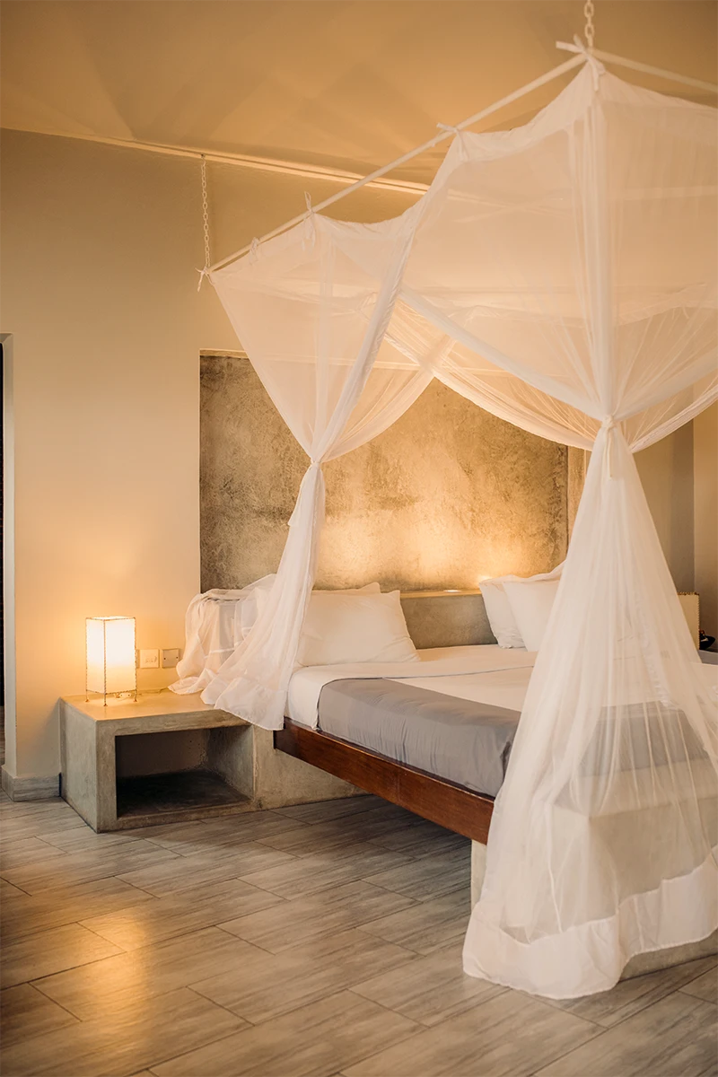 Premium Garden View Suite bedroom with four-poster king-size bed and mosquito net