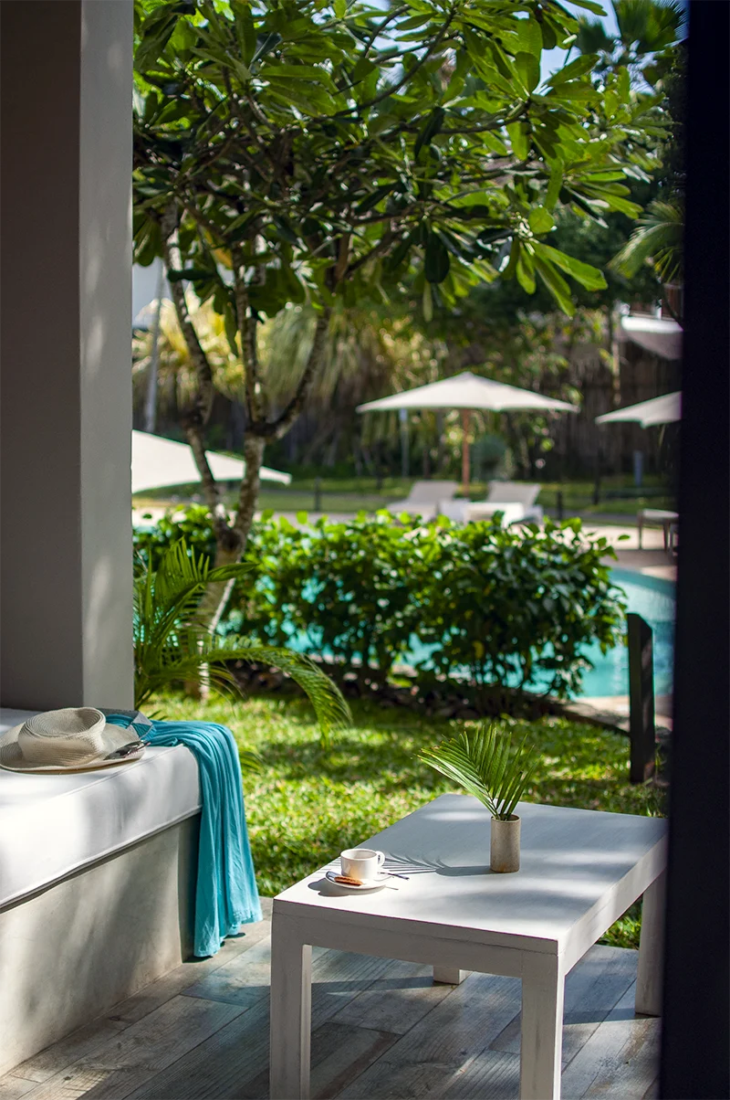 Private outdoor seating area overlooking the tropical garden and pool