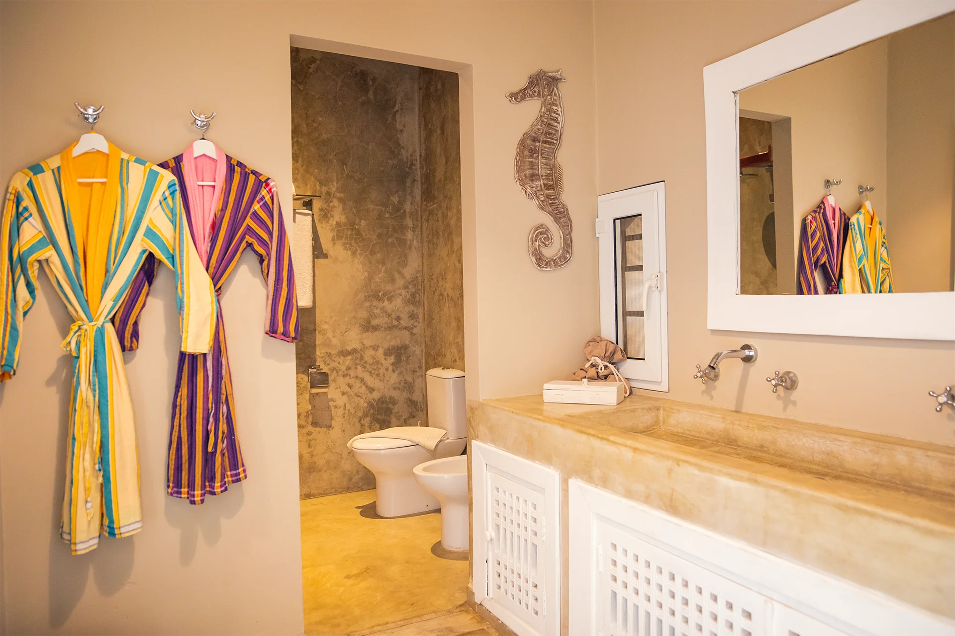 Deluxe Garden View Suite bathroom with colorful bathrobes and walk-in shower