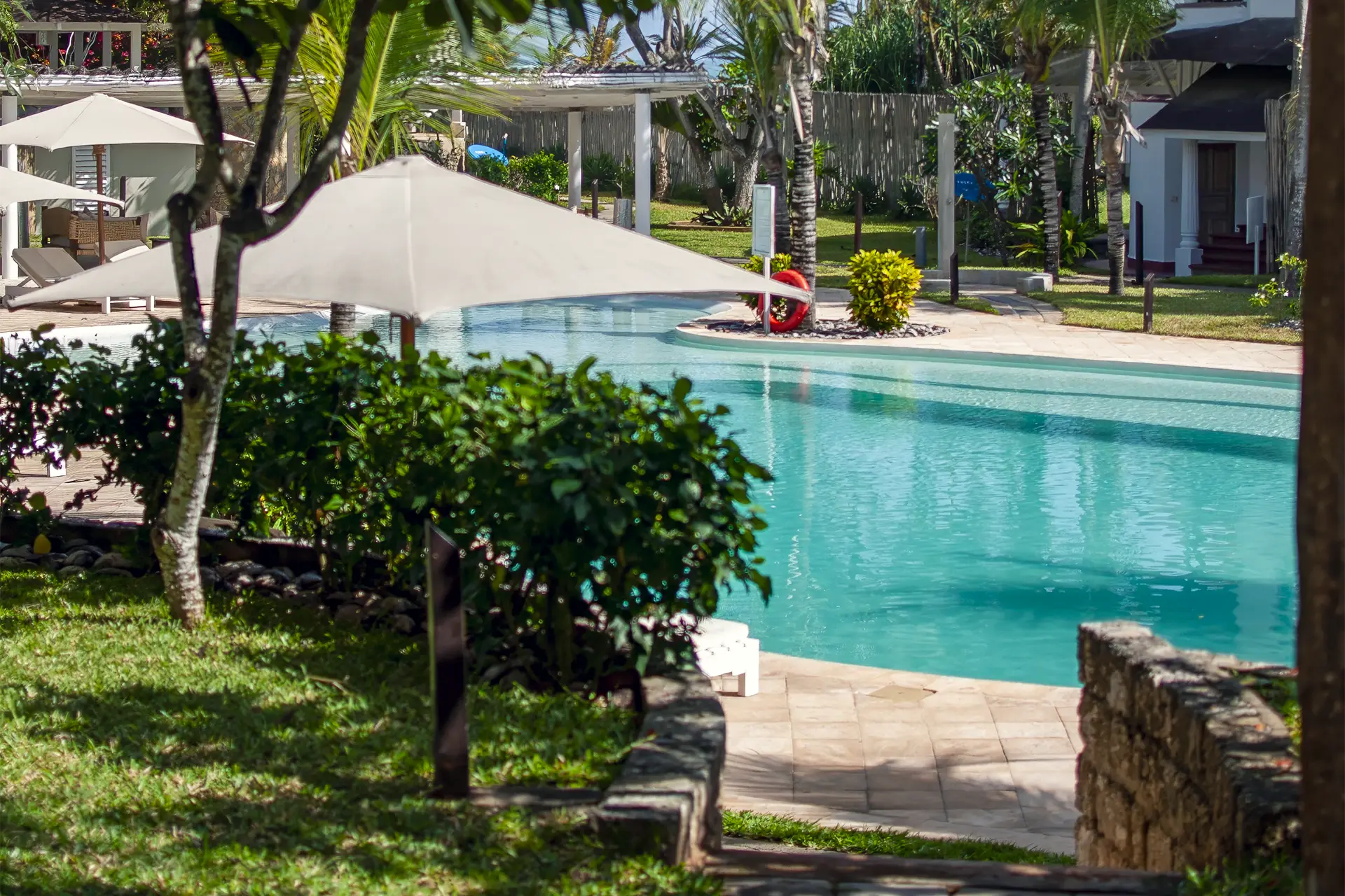Swimming pool surrounded by tropical gardens at Kobe Suite Resort