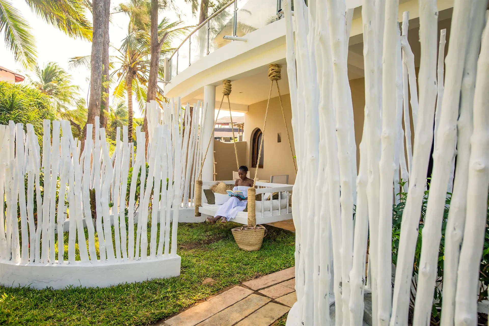 Guest relaxing on a hanging daybed in a private suite garden at Kobe Suite Resort