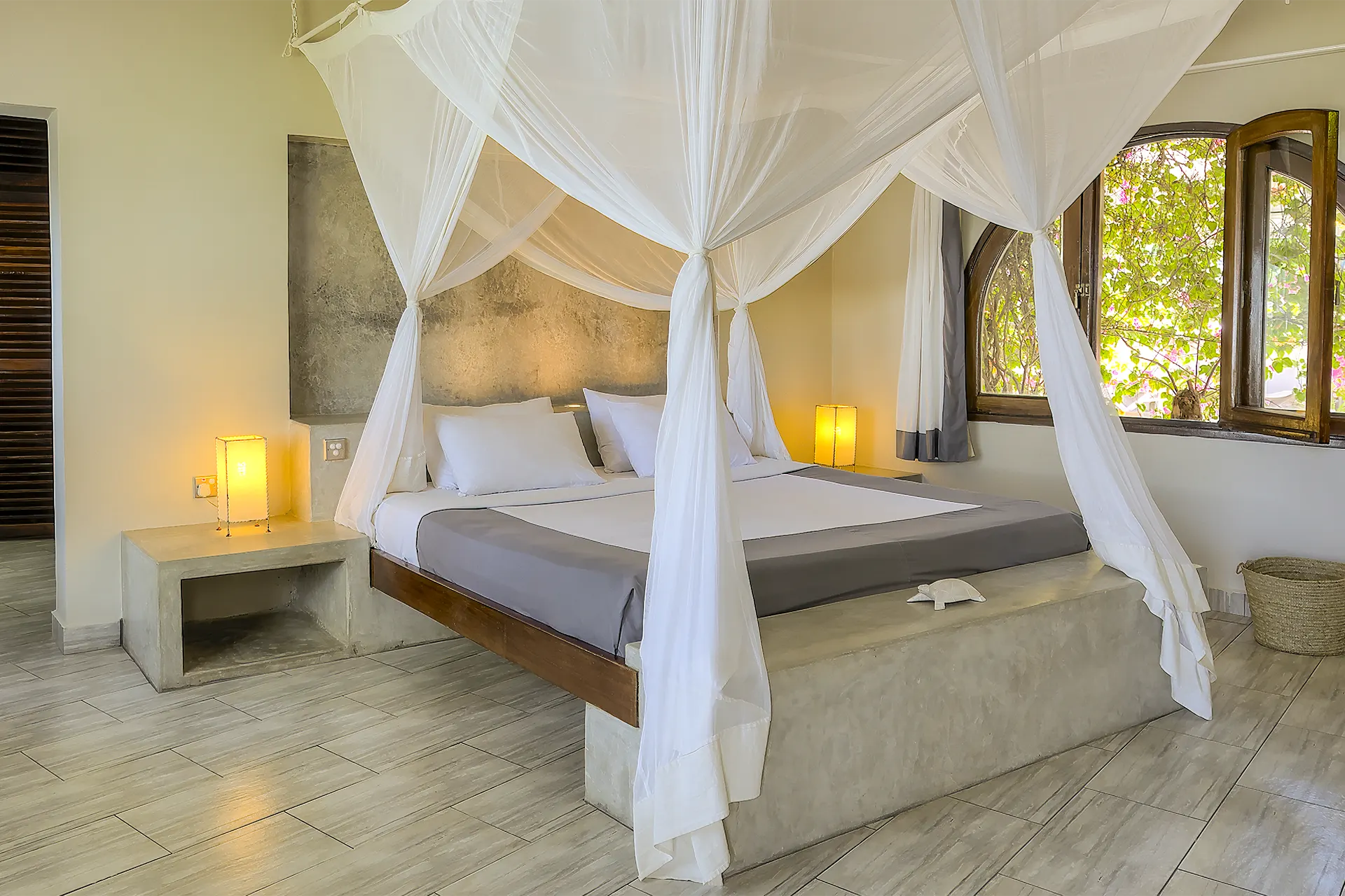 Premium Garden View Suite bedroom with four-poster king-size bed and mosquito net