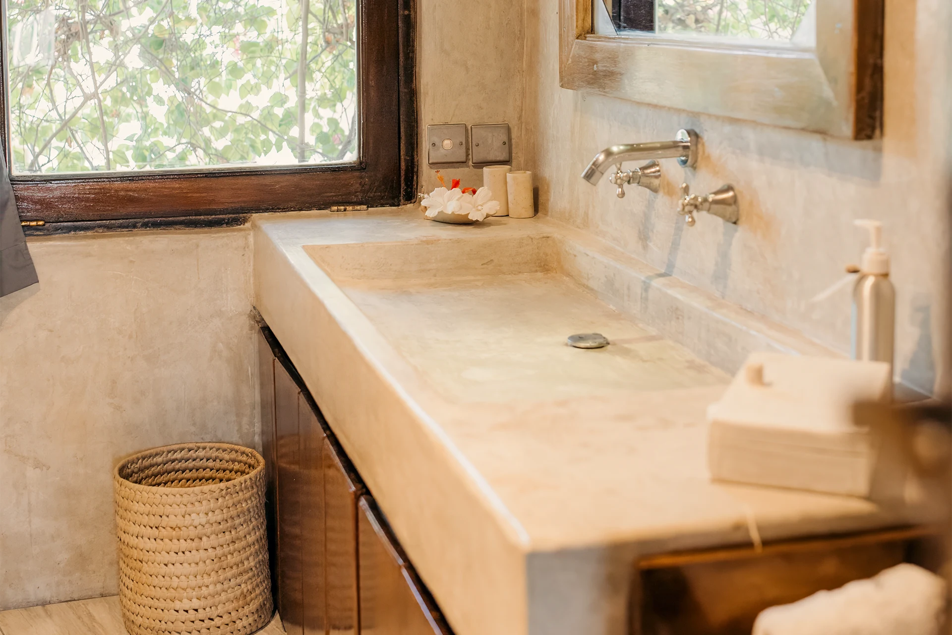 Bathroom with concrete vanity, bathtub and tropical garden view in the Deluxe Garden View Suite