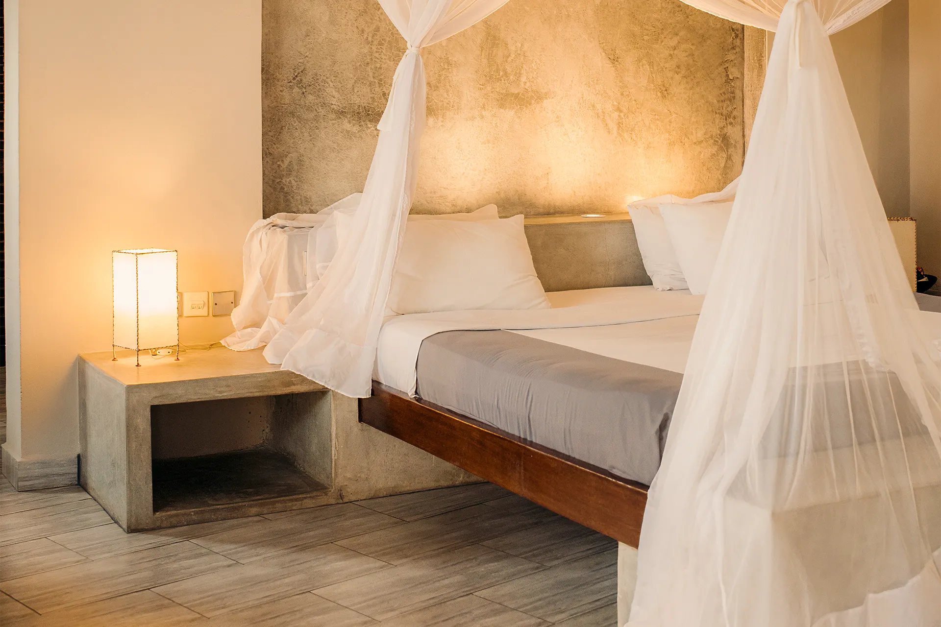 Premium Garden View Suite bedroom with four-poster king-size bed and mosquito net