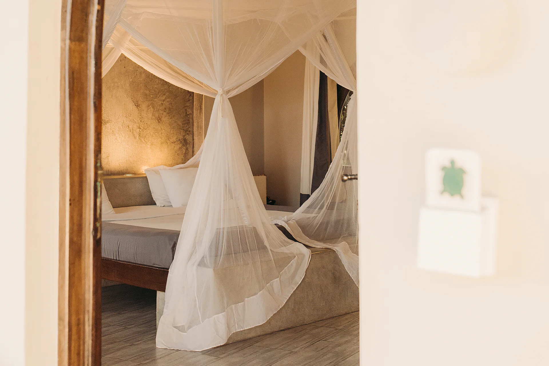 Premium Garden View Suite bedroom with four-poster king-size bed and mosquito net