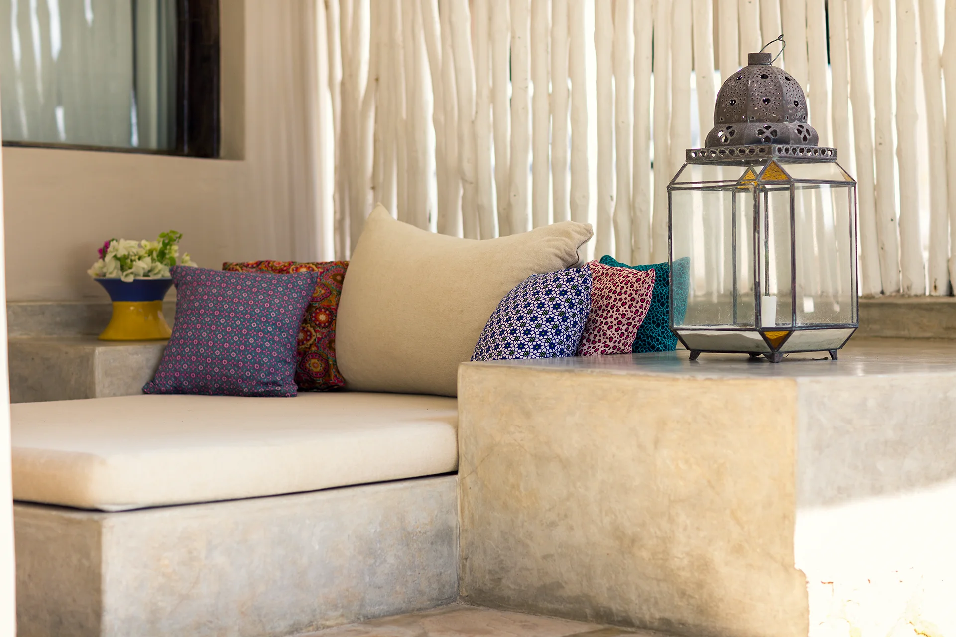 Cushioned seating area with decorative lantern in the Ocean View Suite