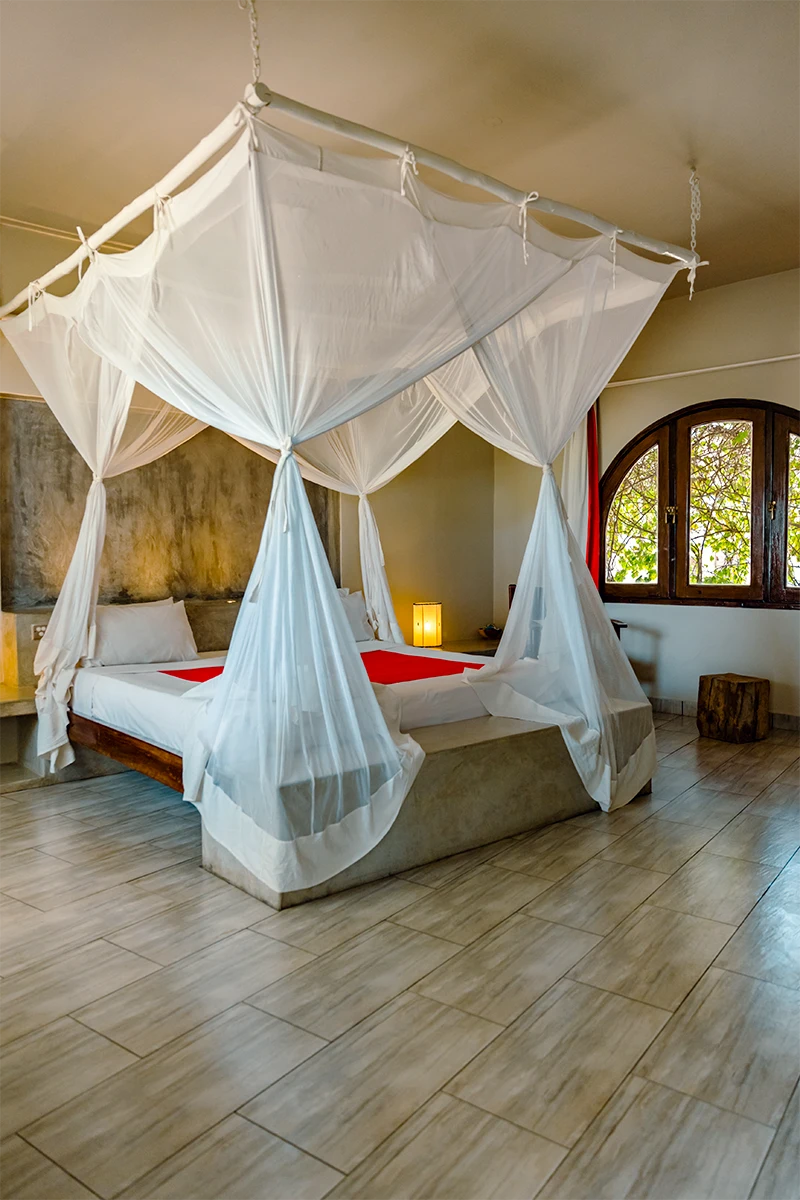 King-size bed with a mosquito net in the Ocean View Suite