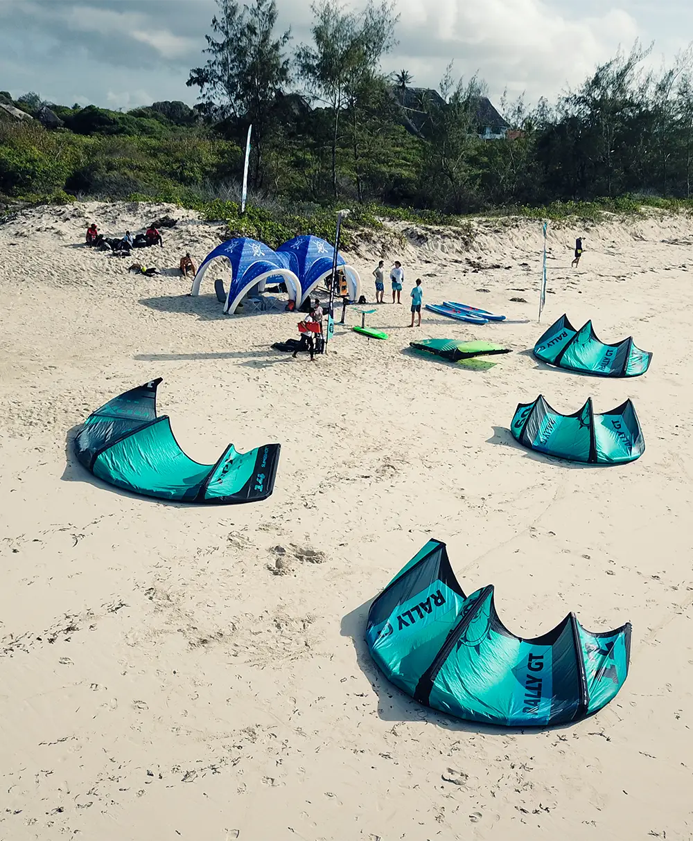 Kitesurfing equipment and sails set up on the sandy beach in Watamu, Kenya