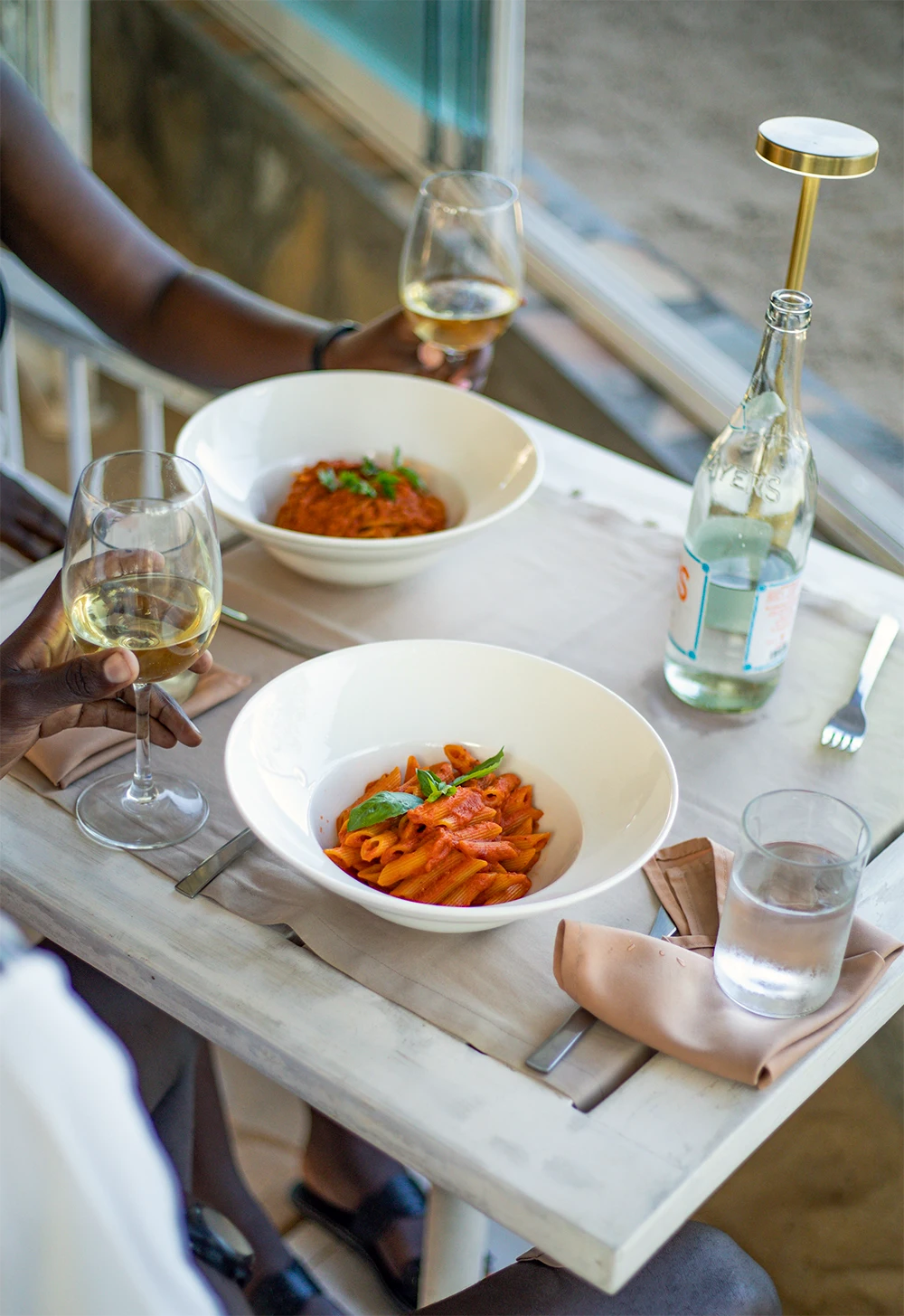 Couple enjoying a dinner with pasta and wine at Kobe Suite Resort