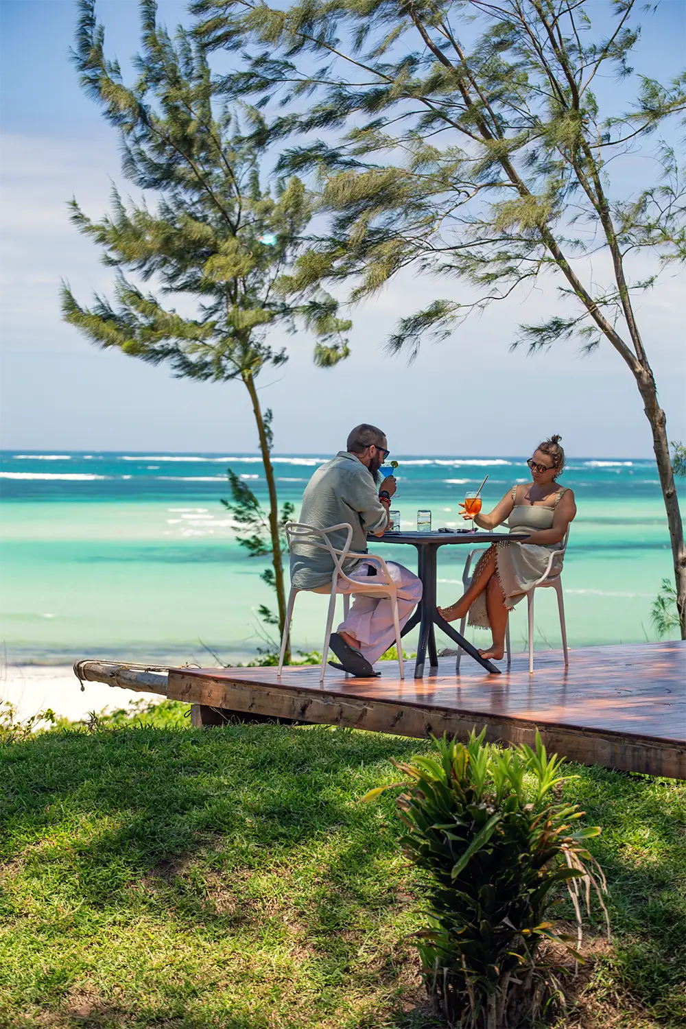 Couple enjoying cocktails on a beachfront terrace overlooking the Indian Ocean