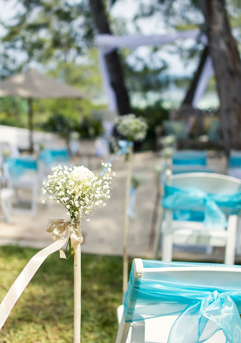 Wedding ceremony decorations with white flowers and turquoise ribbons at Kobe Suite Resort