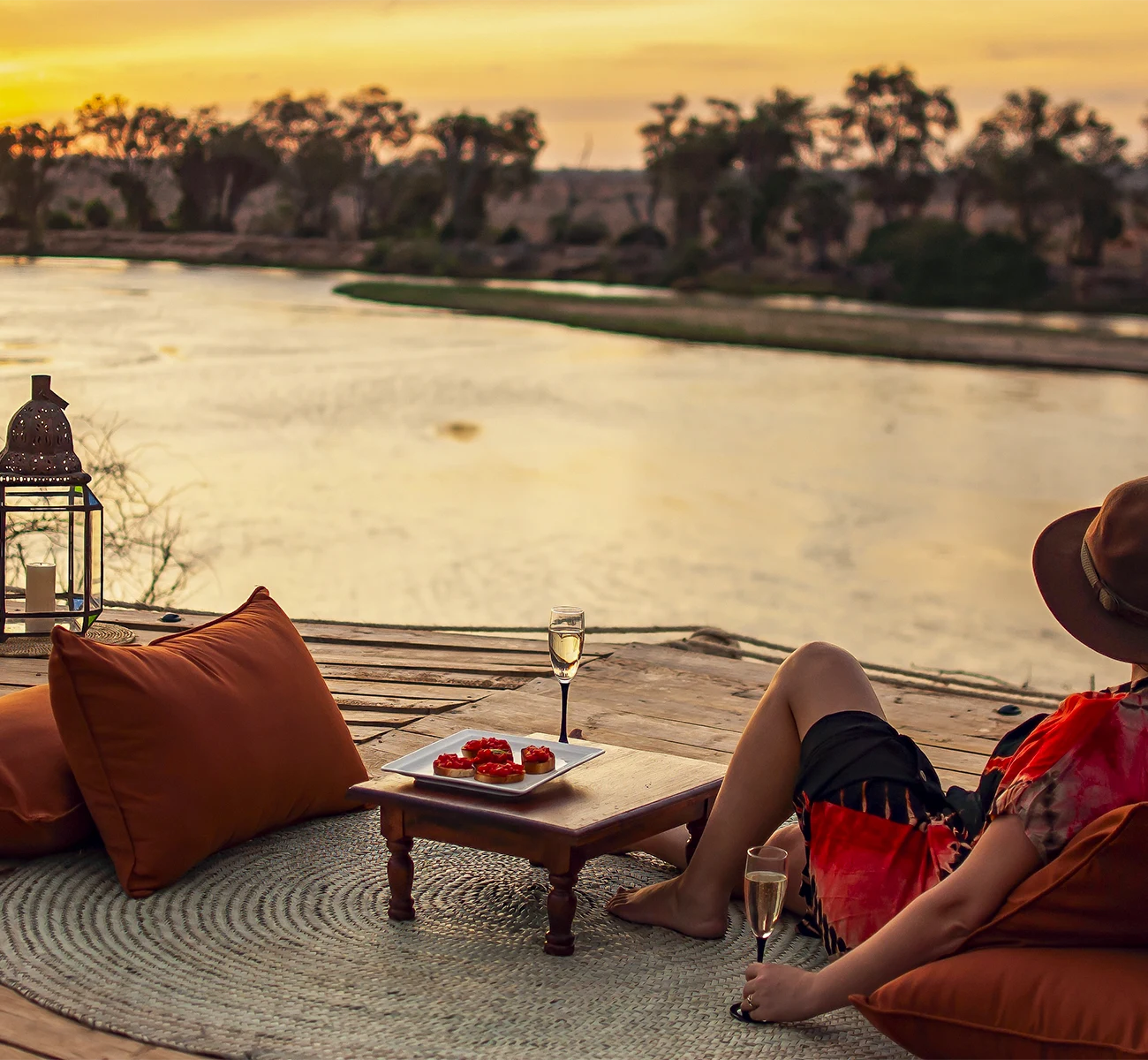 Couple relaxing with drinks overlooking the African landscape at sunset