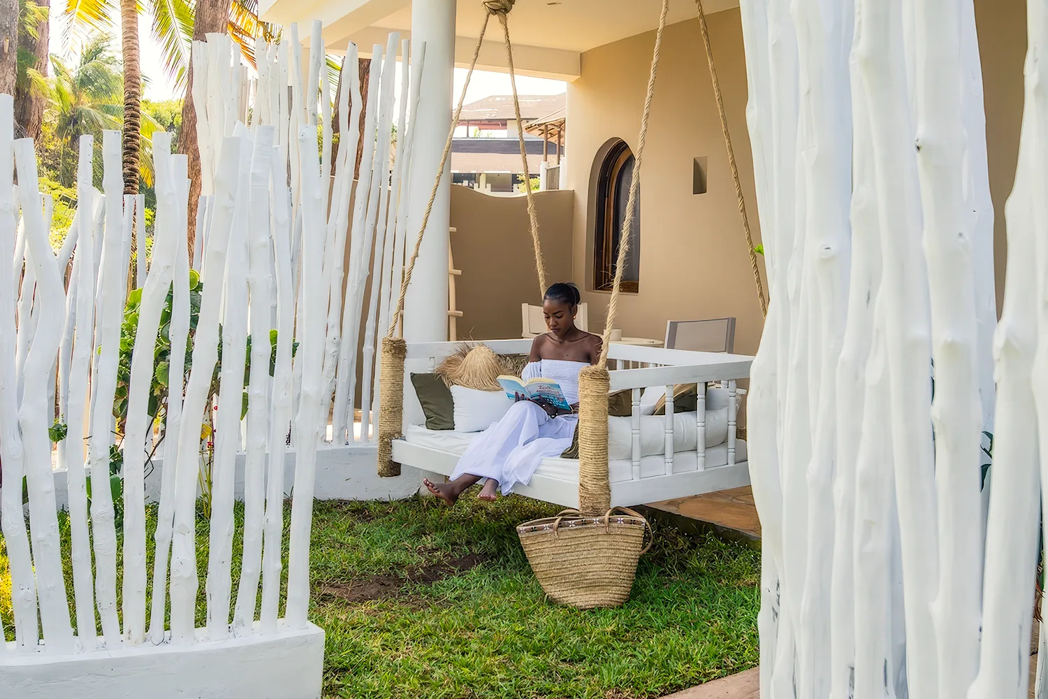 Guest relaxing on a hanging daybed in a private suite garden at Kobe Suite Resort